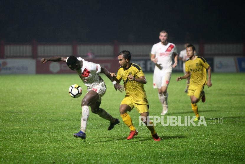 Penyerang PSM Makassar Nke Ondoua Guy (kiri) duel bola dengan Bek Bhayangkara FC Muhammad Fatcu (kanan) pada pertandingan Go-Jek Liga 1 2018 di Stadiun PTIK, Jakarta, Senin (3/12).