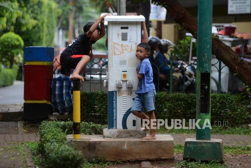 Anak bermain di taman tidak terawat. 