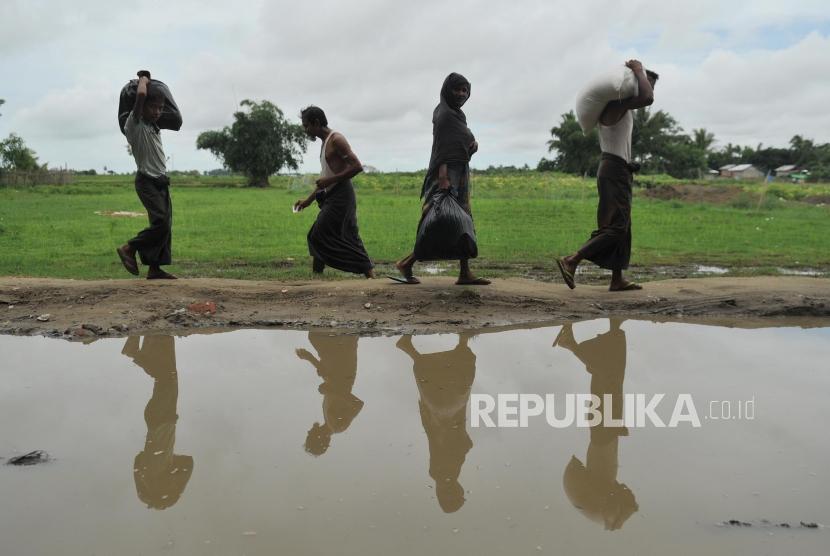 Distribusi Makanan: Warga muslim rohingya membawa bantuan makanan dari sejumlah lembaga zakat yang tergabung dalam Indonesian Humanitarian Alliance (IHA) di Sittwe, Myanmar, Ahad (3/6).