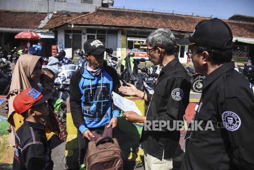 Petugas Disdukcapil memberikan arahan kepada warga pada kegiatan Operasi Simpatik Pendatang di Terminal Leuwipanjang, Kota Bandung, Ahad (9/6).(ilustrasi)