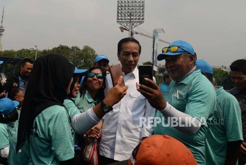 Presiden Republik Indonesia, Joko Widodo, (tengah) berswafoto bersama sejumlah atlet lawn ball saat melakukan peninjauan latihan lawn ball di kawasan Gelora Bung Karno, Jakarta, Kamis (27/9).