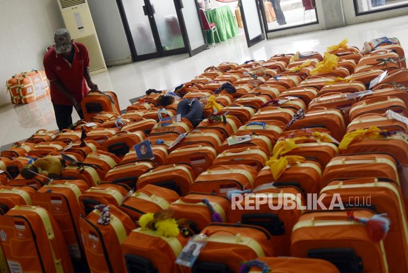 Bekal dan Barang yang Perlu Dibawa Jamaah Haji. Foto: Sejumlah porter merapihkan koper calon jamaah haji di Asrama Haji Pondok Gede, Jakarta, Ahad (14/7).
