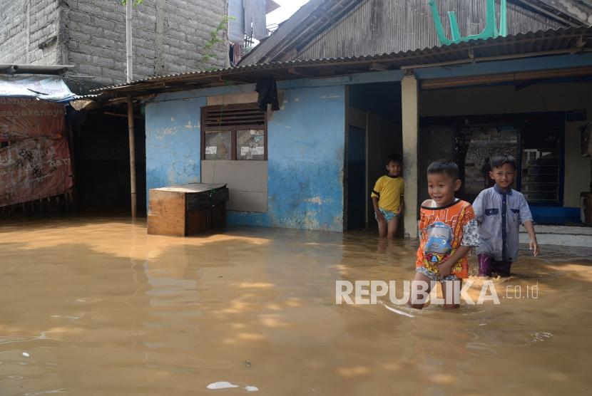Anak-anak beraktivitas ketika banjir melanda permukiman penduduk di Kawasan Pejaten Timur, Jakarta, Jumat (26/4).