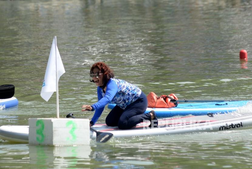 Menteri Kelautan dan Perikanan Susi Pudjiastuti berusaha mengambil bendera pada garis finish saat berlomba adu cepat dengan Wagub DKI Jakarta Sandiaga Uno dalam festival Danau Sunter, Jakarta, Ahad (25/2).