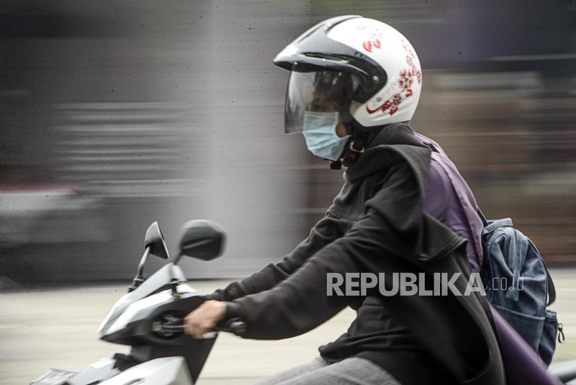 Pengendara motor menggunakan masker saat kabut asap kebakaran hutan dan lahan menyelimuti Kota Pekanbaru, Riau, Selasa (10/9).