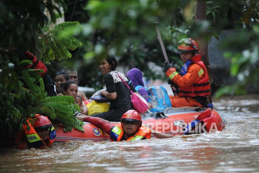 Petugas pemadam kebakaran mengevakuasi warga yang terjebak banjir di kawasan Pejaten Timur,Jakarta, Senin (5/2).