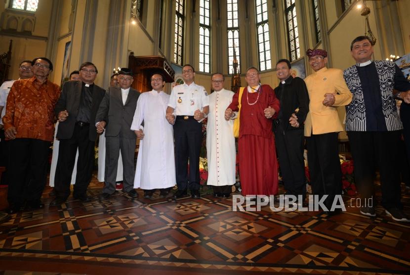 Gubernur DKI Jakarta, Anies Baswedan  (tengah) berfoto bersama  forum kerukuman umat beragama saat melakukan kunjungan perayaan natal di Gereja Katedral Jakarta, Senin (24/12).