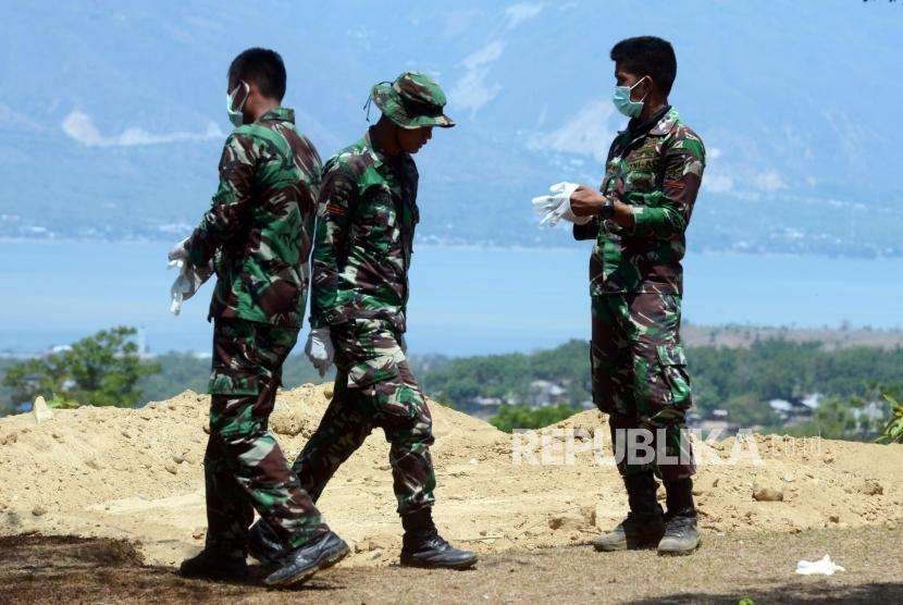 Sejumlah Prajurit TNI melakukan penguburan massal terhadap jenazah korban gempa bumi dan tsunami di Taman Pemakaman Umum (TPU) Poboya Indah, Palu, Sulawesi Tengah, Selasa (2/10).