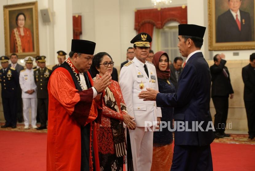 Pelantikan Hakim MK. Presiden Joko Widodo (kanan) bersiap memberikan ucapan selamat kepada Hakim Konstitusi Arief Hidayat (kiri) usai pelantikan Hakim Konstitusi di Istana Negara, Jakarta, Selasa (27/3).