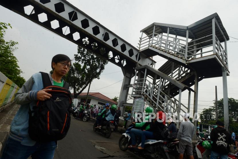 JPO Pasar Minggu. Warga dan kendaraan melintas di dekat Jembatan Penyeberangan Orang (JPO) yang rusak di Pasar Minggu, Jakarta, Selasa (5/3).