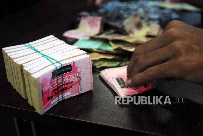 Petugas mengambil tiket untuk calon penumpang KRL Commuter Line di Stasiun Bogor, Bogor, Jawa Barat, Senin (23/7).
