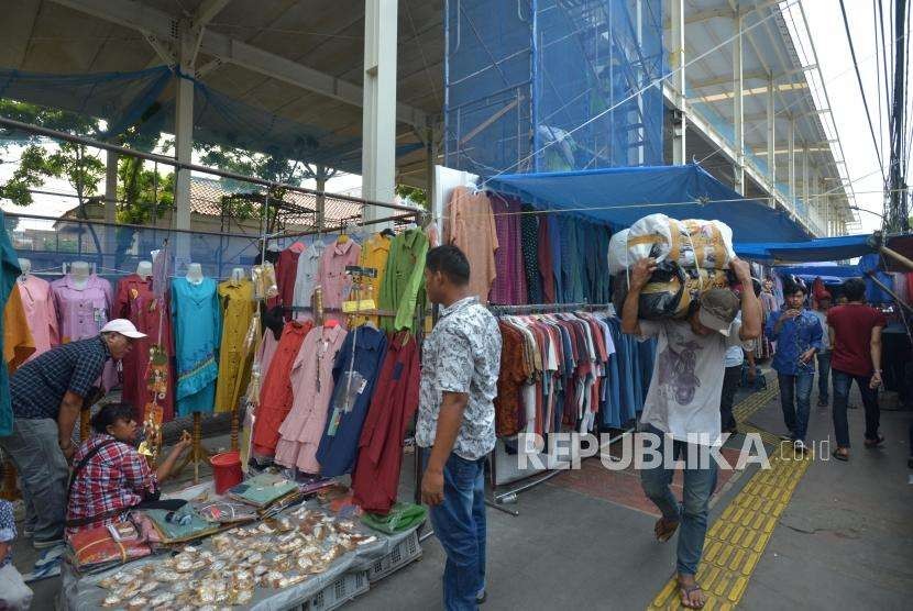 Warga melintas didekat barang dagangan para pedagang di Jalan Jatibaru, Tanah Abang, Jakarta, Kamis (27/9).