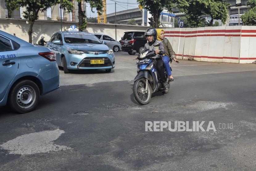 Sejumlah kendaraan melintasi jalan rusak di Rasuna Said Kuningan, Jakarta Selatan, Senin (13/5).