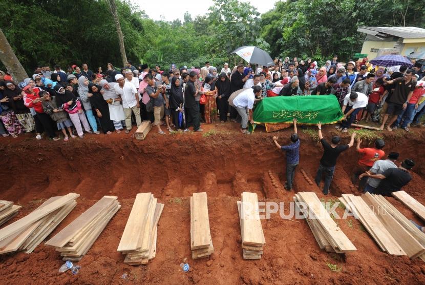 Pemakaman.  Proses pemakaman korban kecelakaan bus maut di Tangerang Selatan, Banten, Ahad (11/2).