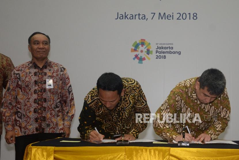 SVP Micro Banking Bank Mandiri Wawan Setiawan (kedua kiri) melakukan penandatanganan kerja sama dengan Managing Director Grab Indonesia Ridzki Kramadibrata (kanan) disaksikan Pejabat Eksekutif Retail Banking Bank Mandiri Donsuwan Simatupang (kiri) di Jakarta, Senin (7/5).