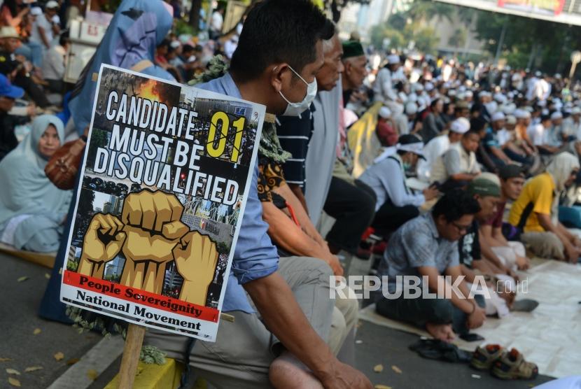 Sejumlah massa saat menggelar doa bersama pada Aksi Tahlil Akbar 266 di Jalan Medan Merdeka Barat, Jakarta, Rabu (26/6).