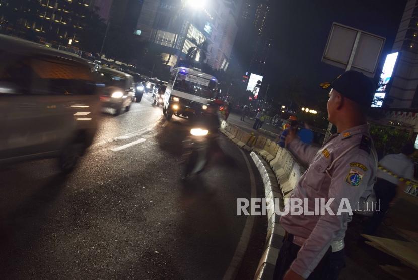 Aktivitas pekerja melakukan perobohan jembatan penyeberangan orang (JPO) di kawasan bundaran HI, Jakarta, Senin (30/7) malam. 