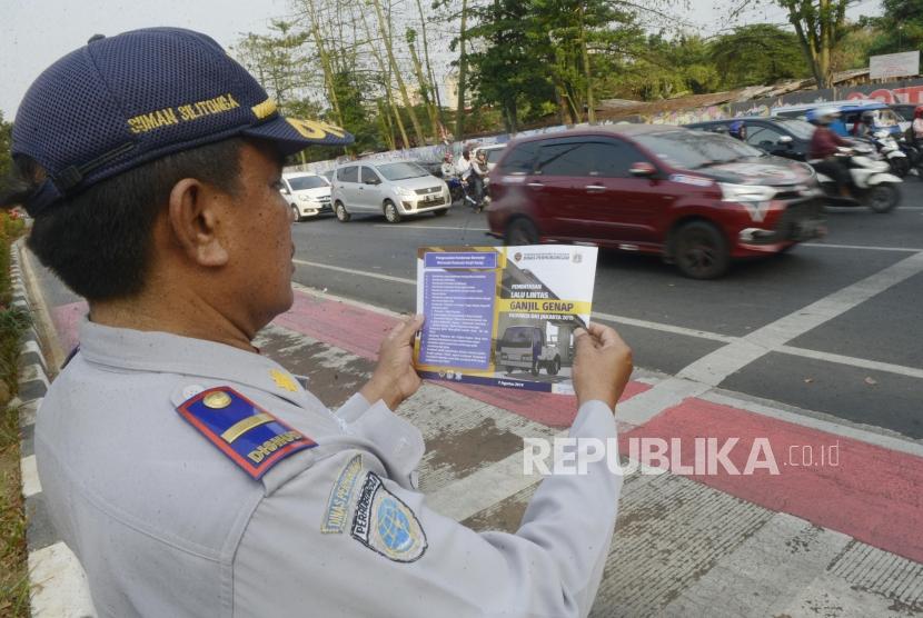 Petugas Dinas Perhubungan DKI Jakarta menunjukan brosur uji coba perluasan sistem ganjil genap kepada pengendara di kawasan Pramuka, Jakarta, Senin (12/8).