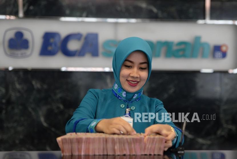 Penambahan Jaringan Kantor Baru. Petugas melayani transaksi nasabah di kantor layanan BCA Syariah, Jakarta, Selasa (13/2).