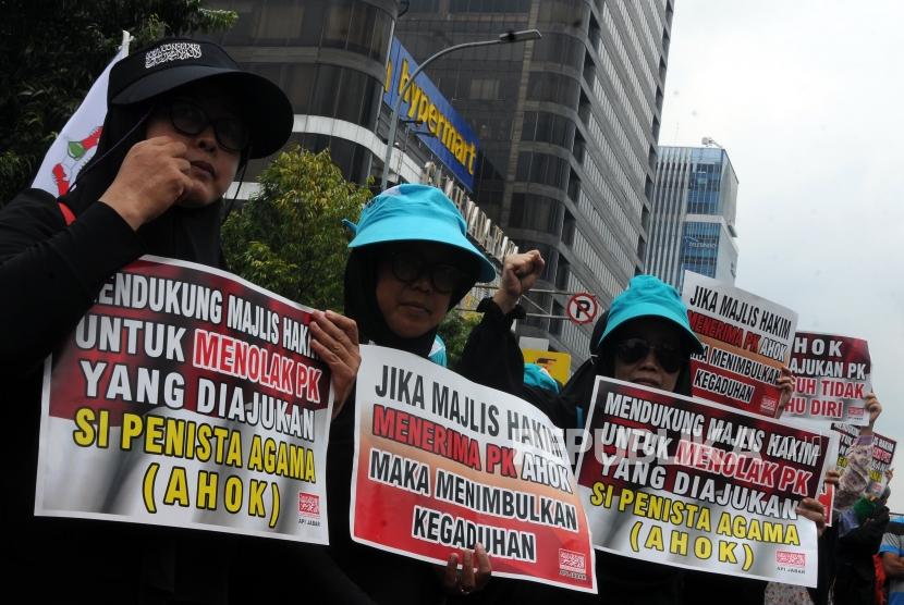 Sejumlah massa melakukan aksi unjuk rasa saat berlangsungnya sidang Peninjauan Kembali (PK) terkait kasus penistaan agama yang menjerat Ahok di depan Pengadilan Negeri Jakarta Utara, Jakarta, Senin (26/2).