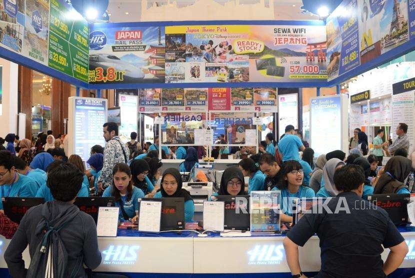 Pengunjung mencari info pemesanan tiket di salah satu stan pada Garuda Indonesia Travel Fair (GATF) phase II 2018 di Jakarta Convention Center, Jumat (5/10).