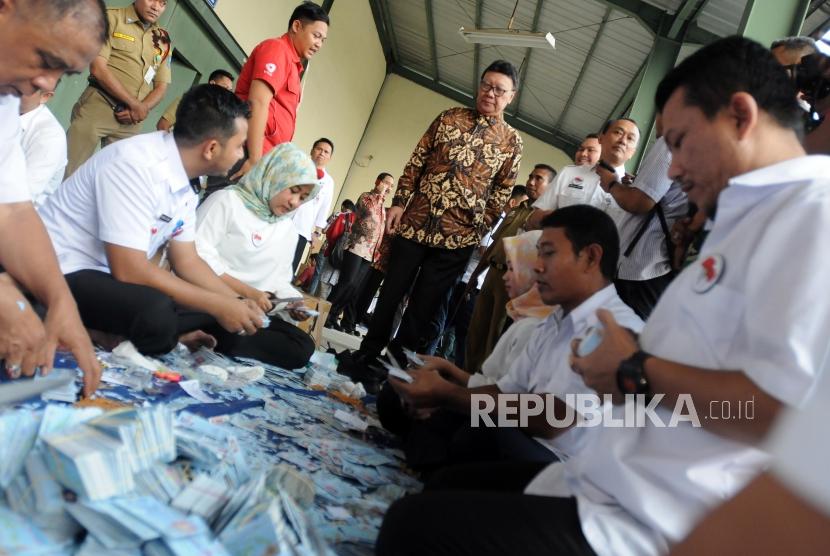 Menteri Dalam Negeri Tjahjo Kumolo (tengah) melihat petugas memotong KTP elektronik yang sudah rusak di BPSDM Kemendagri, Kemang, Bogor, Jawa Barat, Rabu (30/5).