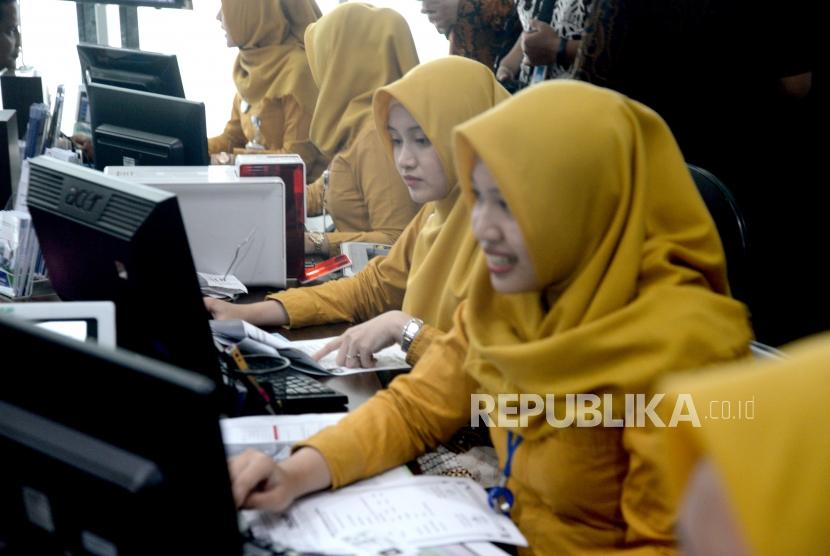 Pemanfaatan KTP-El di BPJS Kesehatan. Petugas melayani pendaftaran JKN-KIS warga menggunakan card-reader KTP Elektronik di Jakarta, Jumat (5/1).