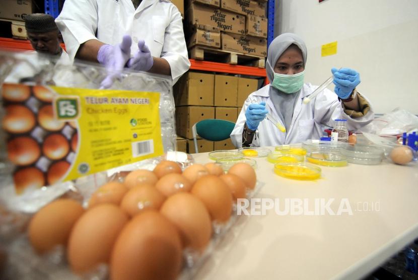 Officers is checking the eggs content in a press conference related to clarification of the existence of fake eggs in Jakgrosir, Kramatjati, East Jakarta, Tuesday (March 20). From laboratory testing, they confirm no fake eggs distributed in the market.