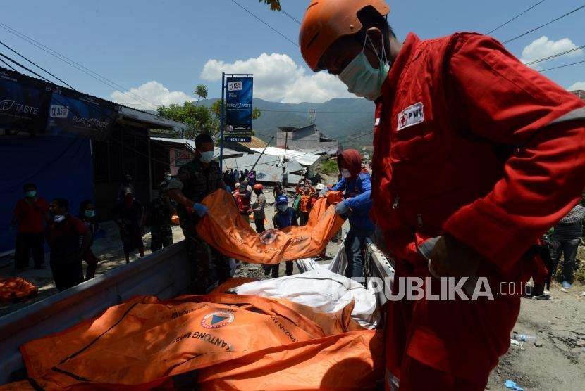 Sejumlah petugas gabungan mengangkut jenazah yang telah terevakuasi untuk diberangkatkan di Perumnas Balaroa, Palu, Sulawesi Tengah, Senin (1/10).