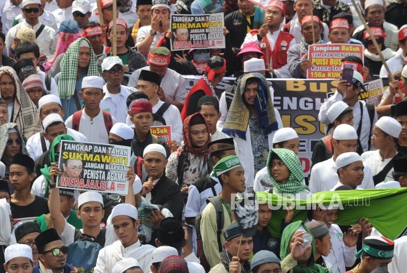 Umat muslim  dari berbagai ormas   membawa poster dalam aksi menuntut tangkap dan penjarakan sukmawati Soekarno Putri yang di lakakukan di depan kantor Bareskrim Mabes Polri, Jakarta, Jumat (6/4).