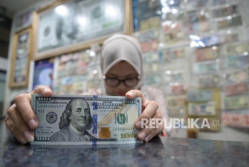 Cadangan Devisa Susut. Pegawai menghitung mata uang dolar AS di jasa penukaran mata uang, Jakarta.