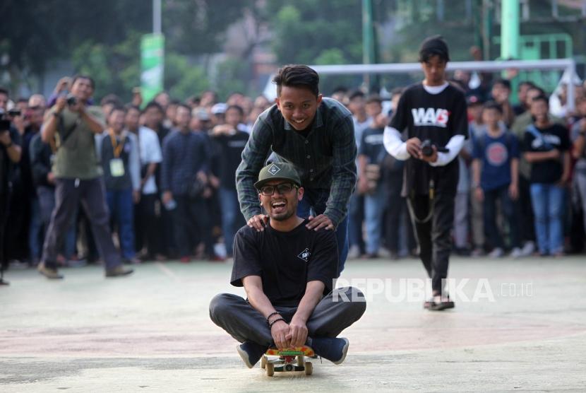 Ustadz Hanan Attaki bermain skateboard saat ngabuburide di Lapangan Blok S, Senopati, Jakarta, Sabtu (26/5).