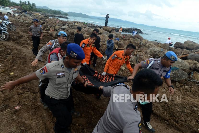 Sejumlah petugas gabungan mengevakuasi jenazah korban tsunami di Desa Way Muli, Kalianda, Lampung Selatan, Senin (24/12).