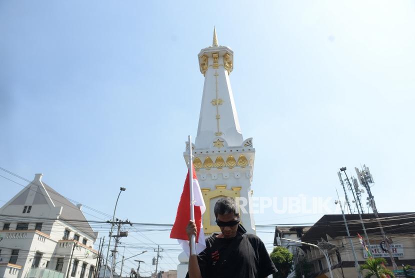 Aktivis Jogja Corruption Watch Baharuddin Kamba saat melakukan aksi jalan mundur di Tugu Pal Putih, Yogyakarta, Jumat (13/9/2019).