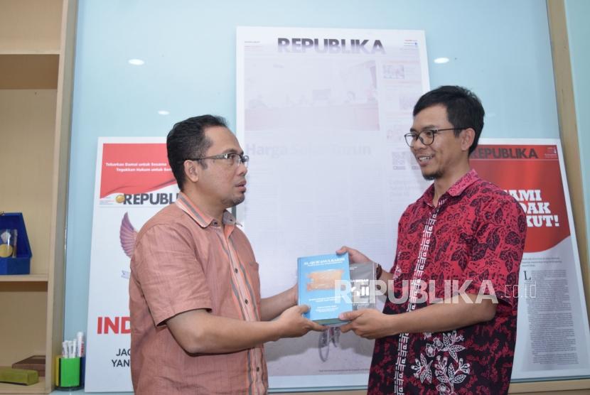 Direktur Rumah Amal Muhammad Kamal Muzakki (kanan) memberikan cinderamata Wakil Pemimpin Redaksi Nur Hasan Murtiaji saat berkunjung ke Kantor Republika, Jakarta, Rabu (31/10).