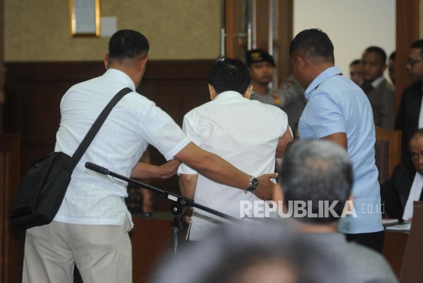 Terdakwa kasus dugaan korupsi KTP elektronik Setya Novanto (Tengah) di boyong keluar ruangan pada sidang perdana  di gedung Pengadilan Tipikor Jakarta, Rabu (13/12).