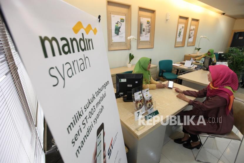 Karyawan Bank Mandiri Syariah sedang melayani nasabah. ilustrasi