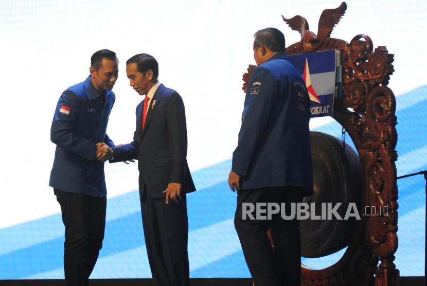 Presiden Joko Widodo (kedua kiri) berjabat tangan dengan Ketua Kogasma Partai Demokrat Agus Harimurti Yudhoyono (kiri) disaksikan oleh Ketua Umum Partai Demokrat Susilo Bambang Yudhoyono (kanan) saat membuka Rapat Pimpinan Nasional (Rapimnas) Partai Demokrat 2018 di Sentul International Convention Center (SICC), Bogor, Jawa Barat, Sabtu (10/3).