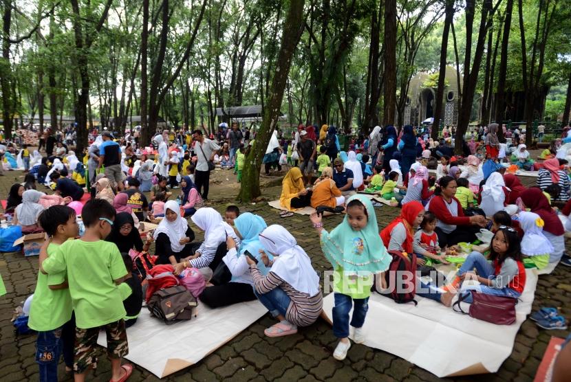 Pengunjung beristirahat saat berwisata di Kebun Binatang Ragunan, Jakarta, Kamis (7/3).