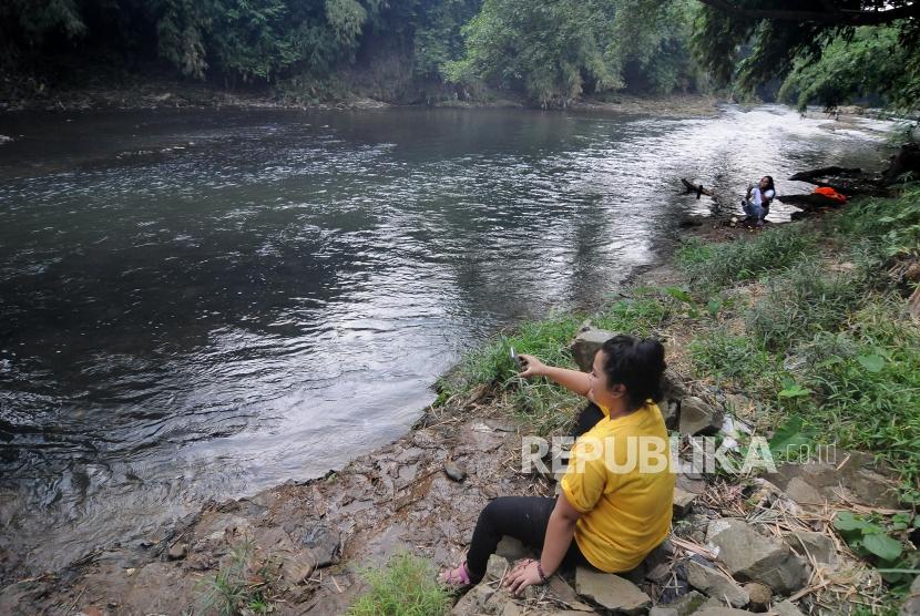 Aliran Sungai Cilwung Surut. Sejumlah warga berwisata di aliran sungai Ciliwung yang surut di Depok, Jawa Barat, Kamis (4/7).