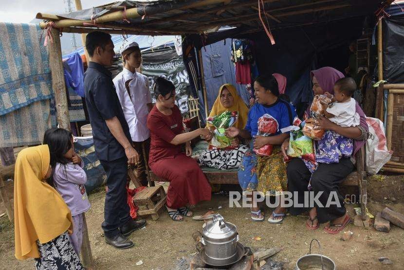 Perwakilan Cinema 21 menyerahkan bantuan kepada warga terdampak gempa bumi di Posko Pengungsian Desa Sembalun Bumbung, Kecamatan Sembalun, Lombok Timur, NTB, Sabtu (25/8).