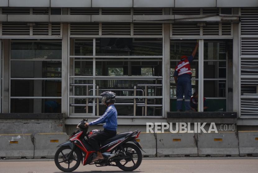 Petugas Dinas Bina Marga Pemprov DKi membersihkan serpihan kaca di halte Transjakarta Petamburan Slipi, Jakarta, Kamis (26/9/2019).