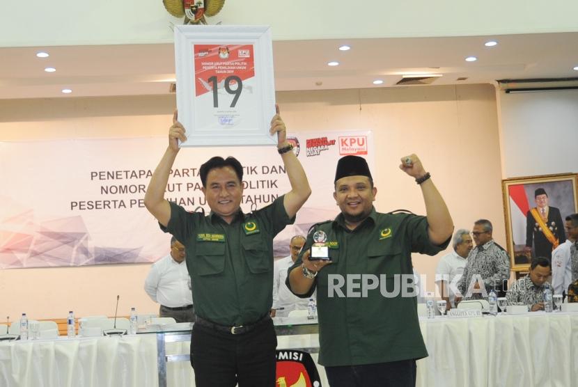 Ketua  Umum Partai Bulan Bintang Yusril Ihza Mahendra bersama Sekjen PBB Ferry Afriansyah Noor menunjukan nomor urut sembilan belas saat acara Pengundian Nomor Urut Peserta Pemilu 2019 di Kantor KPU, Jakarta, Ahad (18/2).