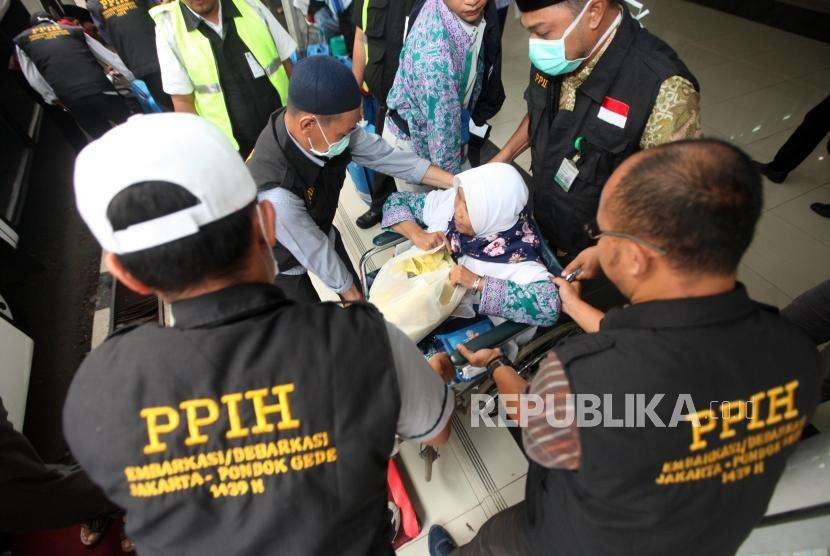 Petugas membantu Jamaah Haji Indonesia Kloter 19 Debarkasi Jakarta Pondok Gede (JKG) menaiki kursi roda saat tiba di Asrama Haji Pondok Gede, Jakarta, Rabu (5/9).