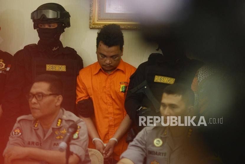 Tersangka kasus pembunuhan satu keluarga HS diperlihatkan kepada media saat konferensi pers di Polda Metro Jaya, Jakarta, Jumat (16/11).