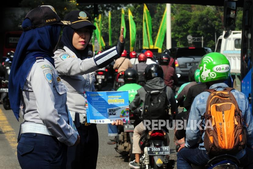Petugas Dinas Perhubungan mengatur lalu lintas saat hari pertama uji coba perluasan ganjil genap di kawasan Pancoran, Jakarta Selatan, Senin (2/7).