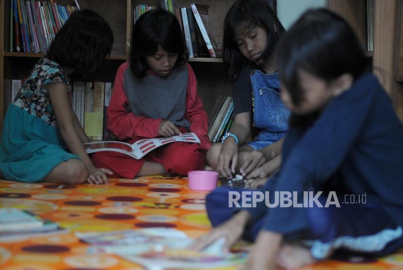 Anak-anak membaca buku di Taman Baca Bulian, Jagakarsa, Jakarta, Senin (12/3).