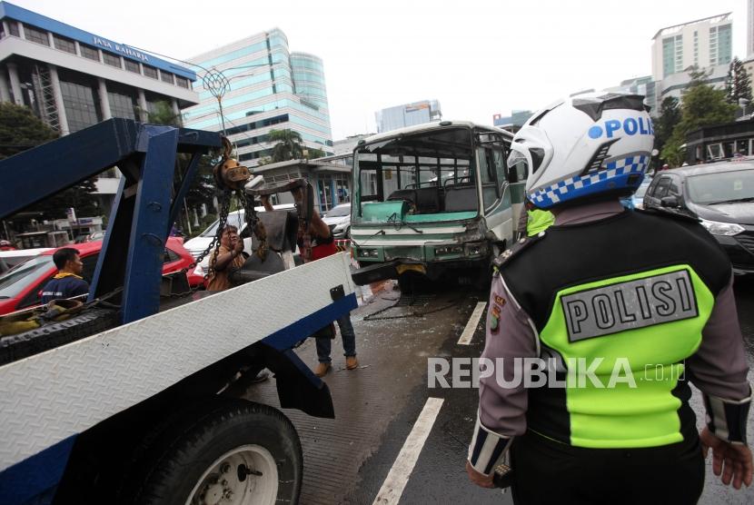 Petugas menderek bus Kopaja yang rusak akibat tabrakan dengan mobil sedan jenis Honda HR-V di Jalan Rasuna Said, Jakarta, Kamis (26/4).