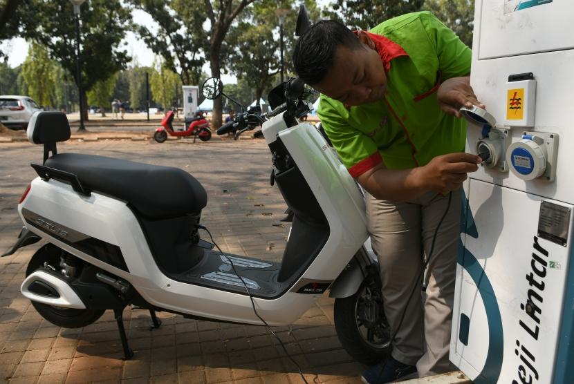 Seorang petugas mengisi ulang sepeda motor listrik disela-sela konvoi mobil listrik di Parkir Timur Gelora Bung Karno (GBK) Senayan, Jakarta, Jumat (20/9/2019).
