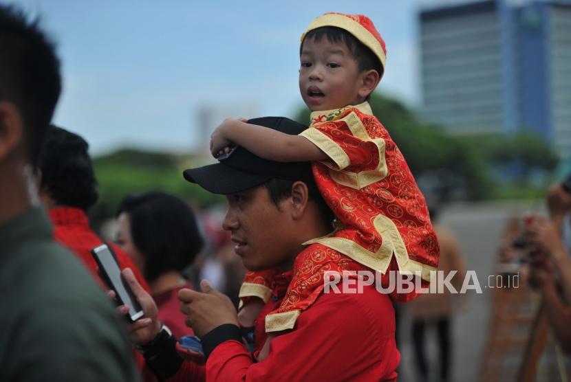 Seorang anak digendong orang tuanya saat menghadiri Perayaan Imlek Nasional 2019 di JI Expo Kemayoran, Jakarta, Kamis (7/2).